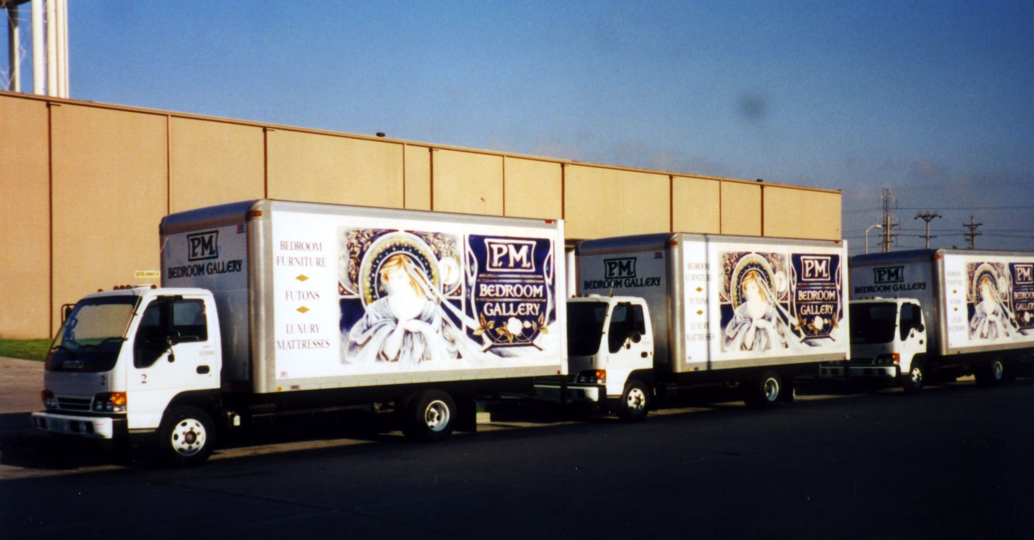 A line of Penny Mustard Bedroom Gallery delivery trucks on their way to deliver furniture