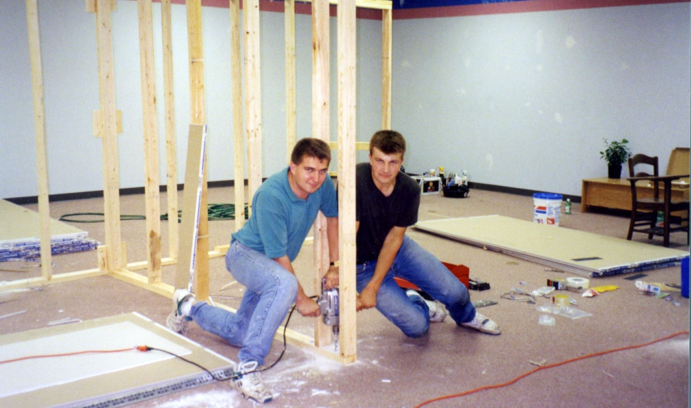 The founders of Penny Mustard work on building elements of their original store while looking at the camera