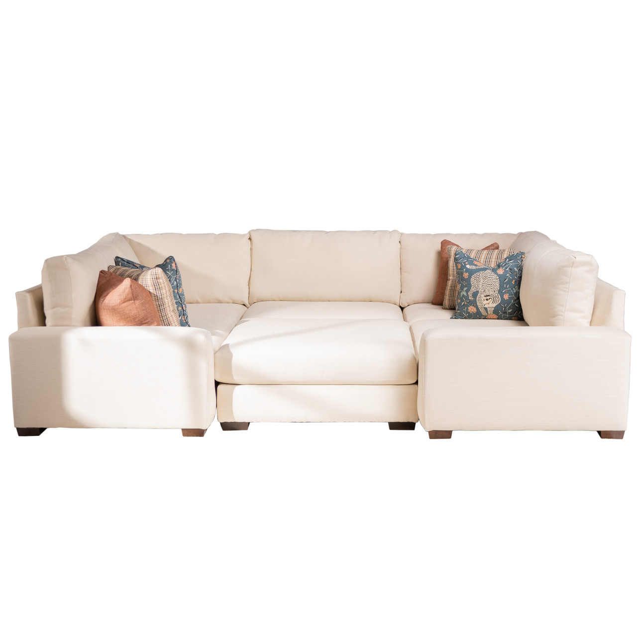 The Miles Modular Sectional from Penny Mustard in cream colored cloth sits on a field of white