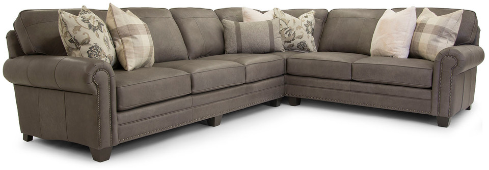 The Smith Brothers Sectional in Leather with decorative throw pillows sits on a field of white