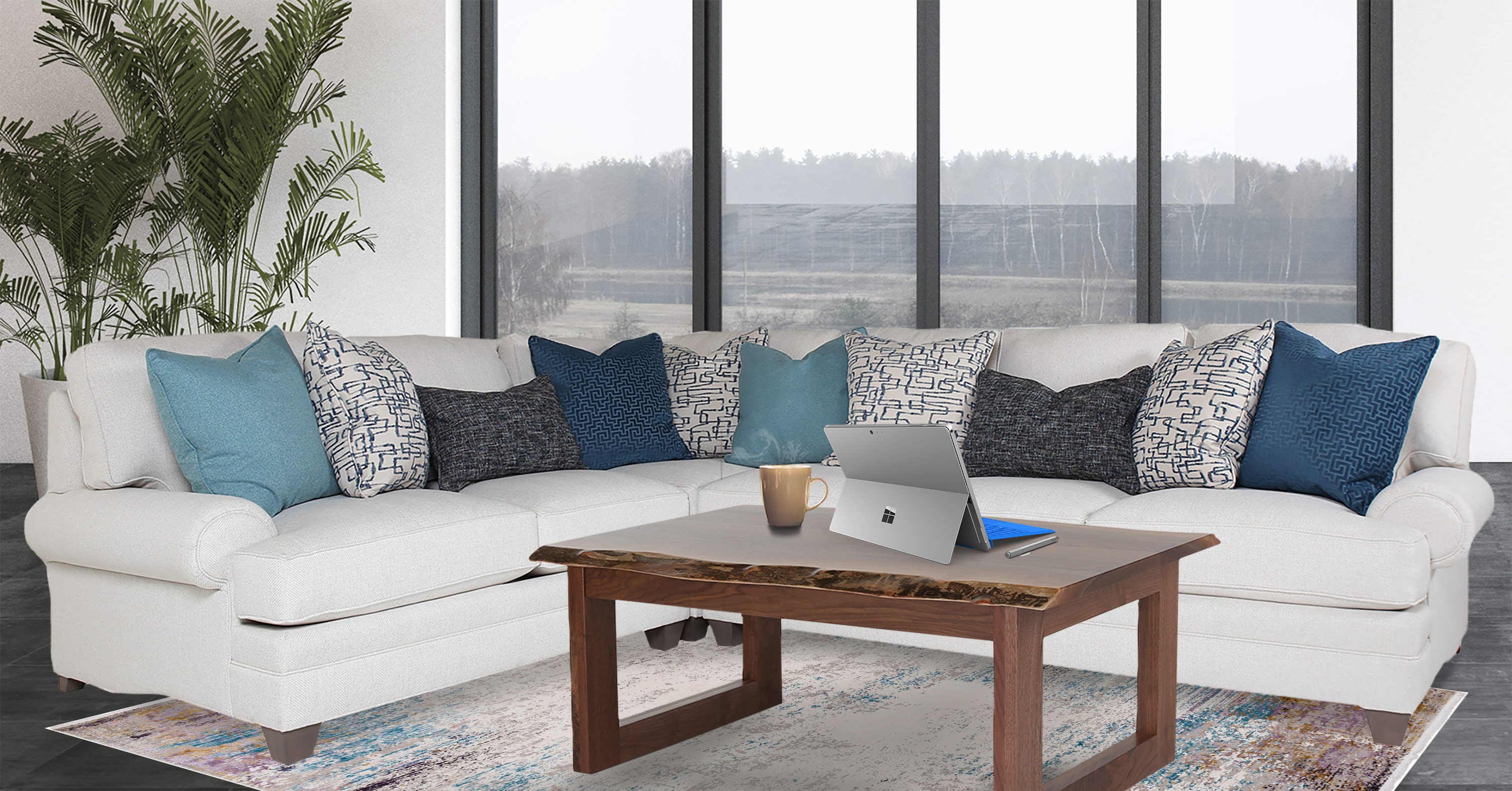 A large white sectional with decorative throw pillows sits against a large floor to ceiling window