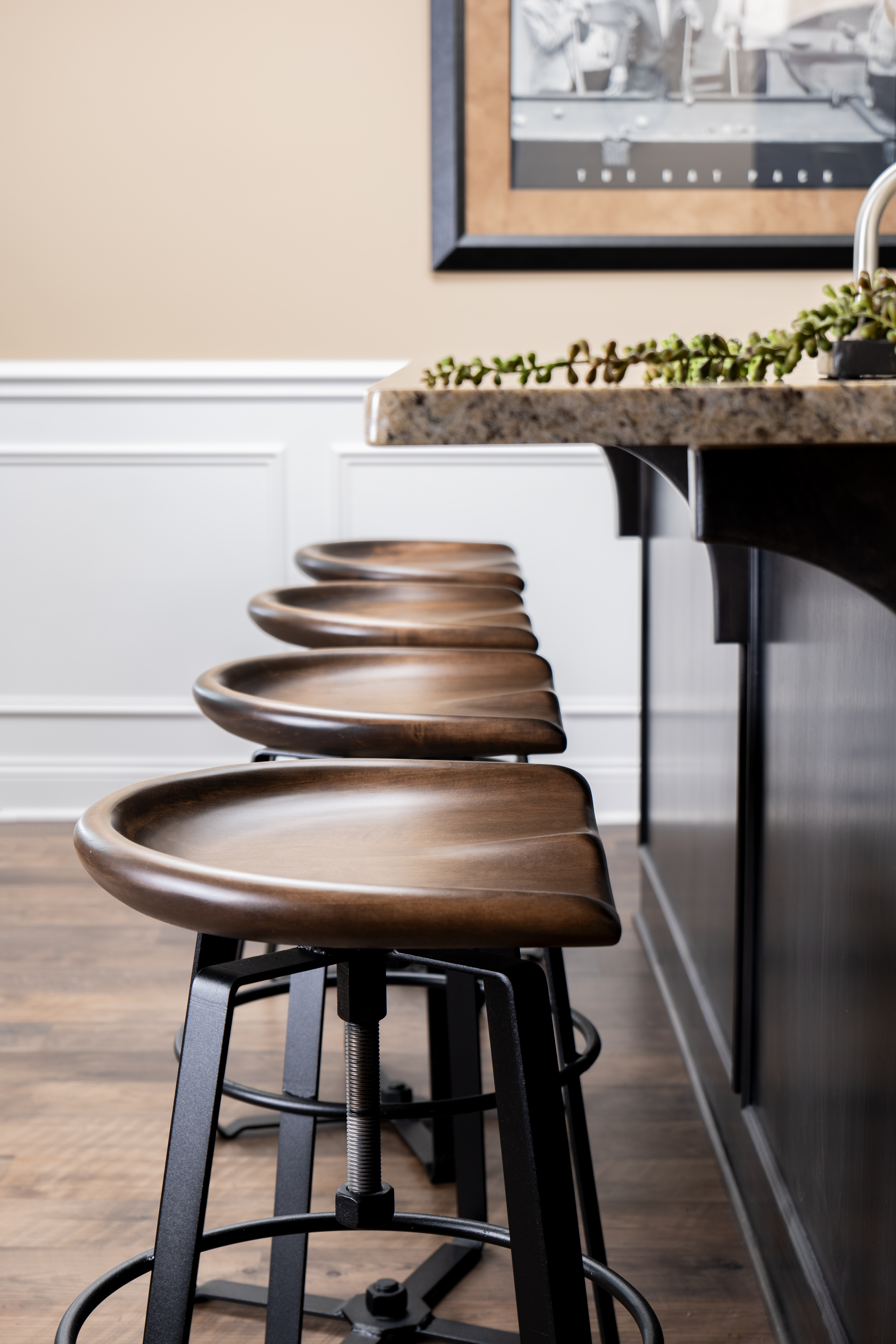 Curves and Soft Lines are demonstrated by a symmetrical row of bar stools with sweeping rounded edges and black metal frames in front of a home kitchen bar