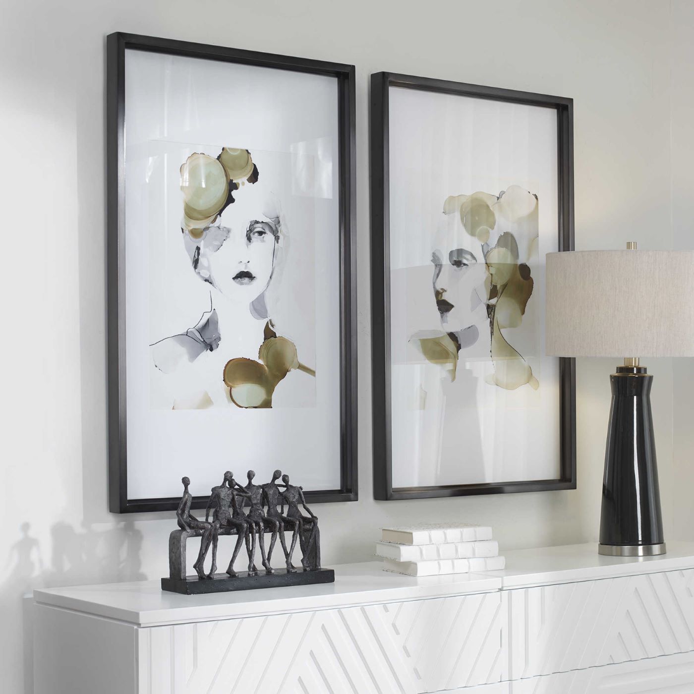 The UT4509 Wall Hangings of two artistically rendered women composed of white and light green splotches hangs behind a credenza that is topped with decor