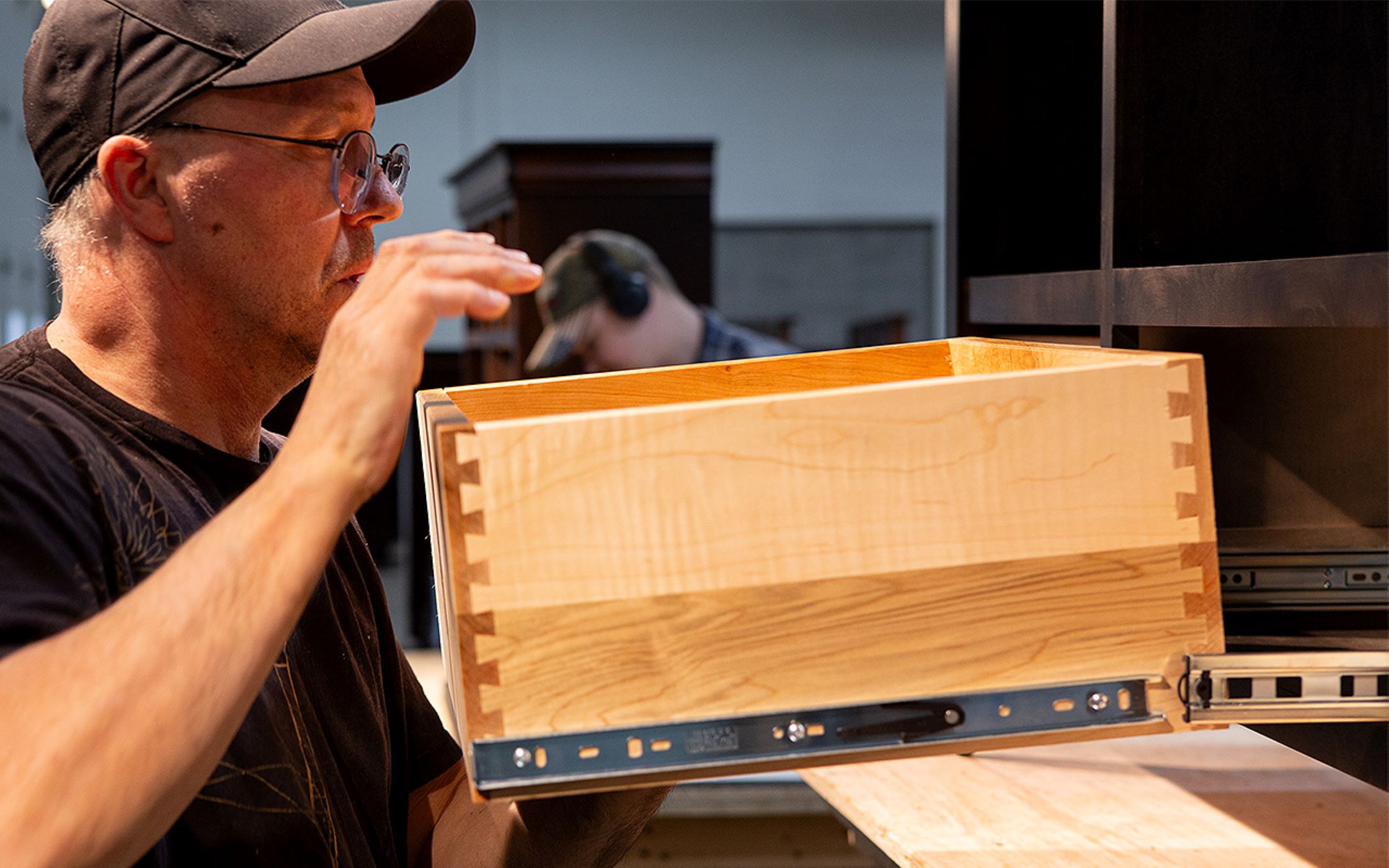 A Craftsmen from the Mystic Creek Woodshop works on a sliding drawer for a piece of furniture