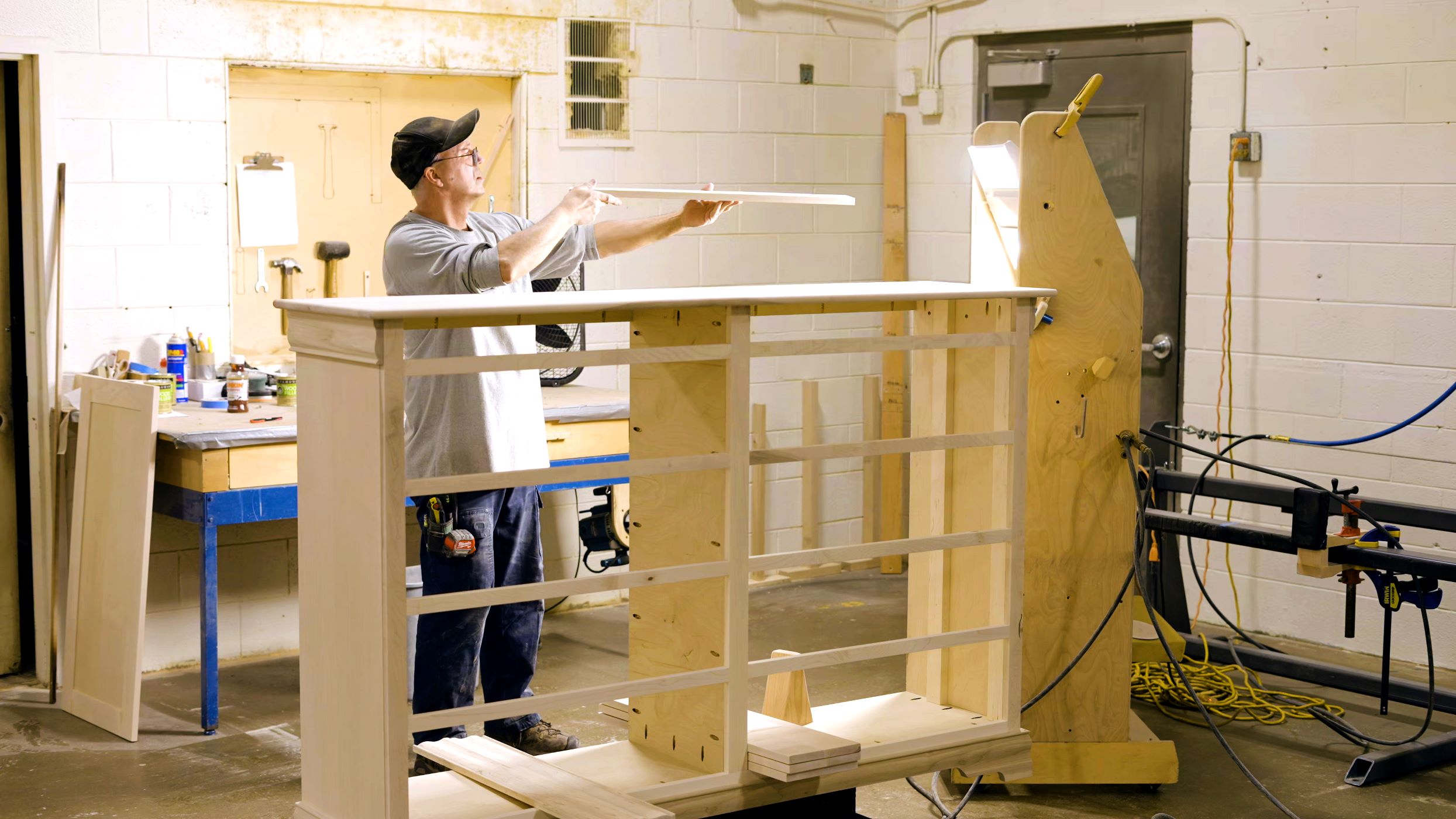 A Craftsmen from Mystic Creek Woodshop works on putting a chest of drawers together