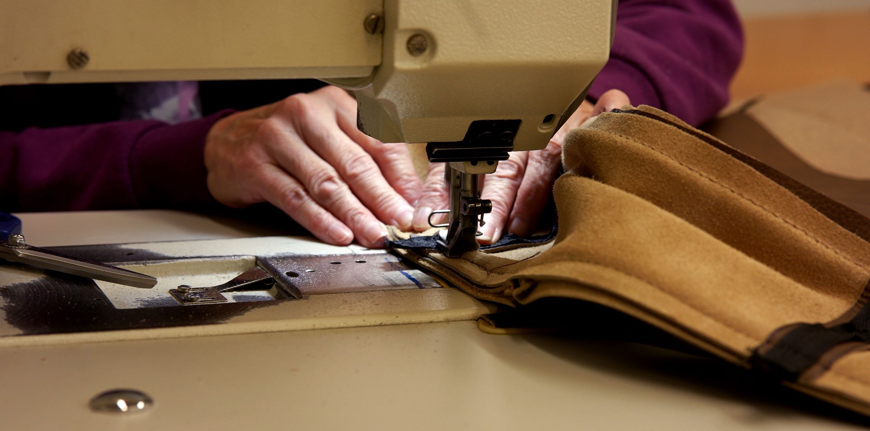 A close up shot of a  seamstress from Marshfield Furniture working on sewing furniture covers together for a piece